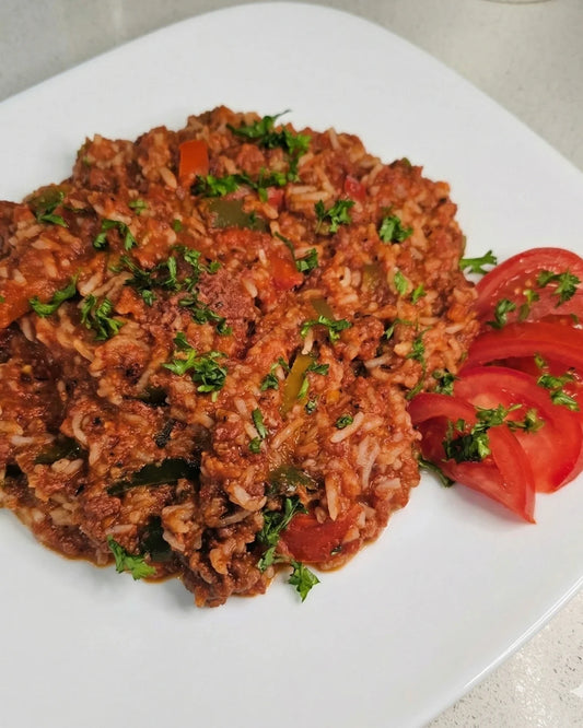 rice dinner with a side of tomatoes on white plate