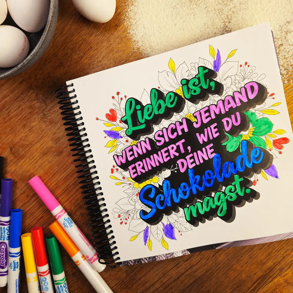 More Baking Just Like Oma Journal Edition black and white spiral cookbook showing German quote coloring page “Liebe ist wenn sich jemand erinnert …” for heritage bakers.