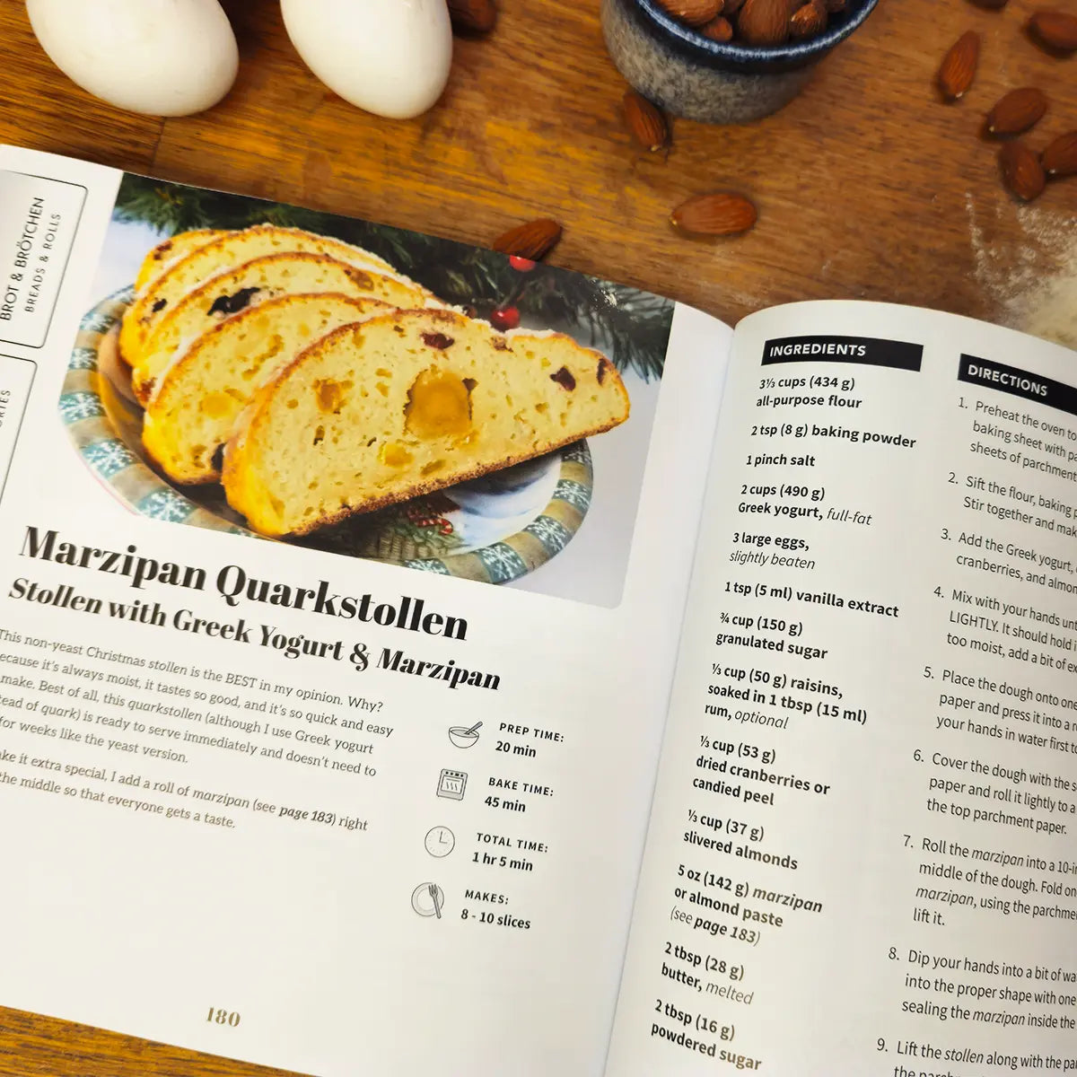 Open More Baking Just Like Oma paperback cookbook showing Marzipan Quarkstollen recipe with Greek yogurt and marzipan, traditional German baking book for home cooks.