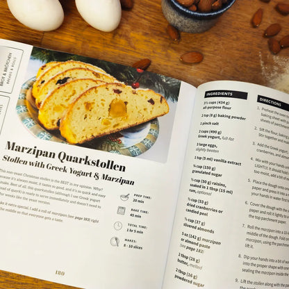 Open More Baking Just Like Oma paperback cookbook showing Marzipan Quarkstollen recipe with Greek yogurt and marzipan, traditional German baking book for home cooks.